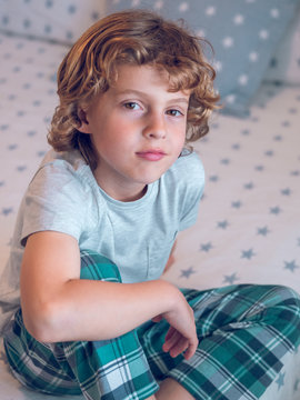 Adorable boy sitting on bed