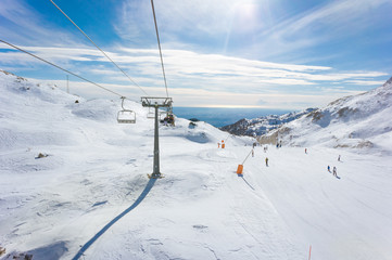 Fototapeta na wymiar Skilift and slopes in Piancavallo in a sunny winter day, near Mount Tremol and Cima Manera, Friuli Venezia Giulia