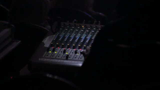 DJ controls sound console at the concert, close-up