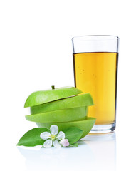 Glass of fresh organic juice and green apple with leaves and spring flowers