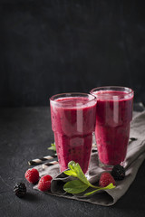 Blackberry and raspberry smoothies in glass with mint leaf and raw beeries
