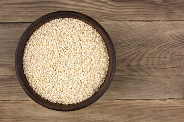 White sesame in a bowl on wooden background