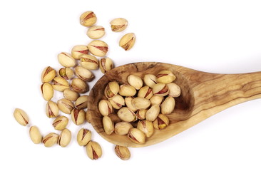 Pistachios in wooden spoon isolated on white background, top view