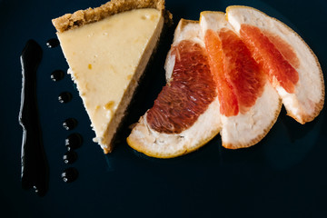 Cheesecake with grapefruit and chocolate on blue plate