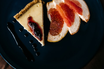 Cheesecake with grapefruit and chocolate on blue plate