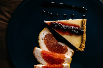 Cheesecake with grapefruit and chocolate on blue plate