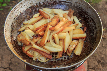 Fried potatoes in a frying pan in field conditions