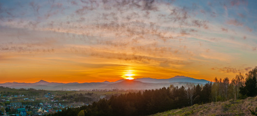 Panorama of the setting sun on the mountains in the summer. Gorno-Altaisk.