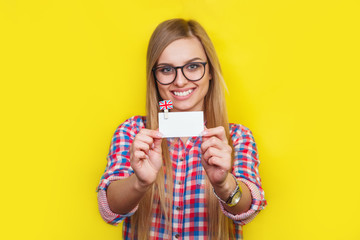 Learning and study concept. Young woman with English flag and card