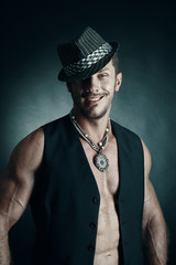sexy and naked muscular young man standing witn hat and smile