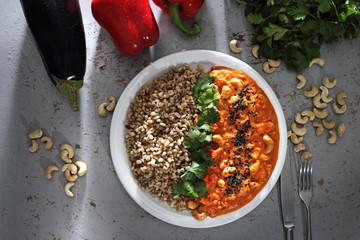Czerwone curry.
Danie obiadowe. Kolorowe warzywa w sosie podane z kaszą i ziolami
 - obrazy, fototapety, plakaty