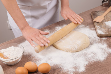 Hands working with dough preparation recipe bread. Female hands making dough for pizza. Woman's hands roll the dough.