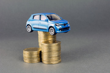 concept of auto dealership and rental, new car buy. toy car stack of coins