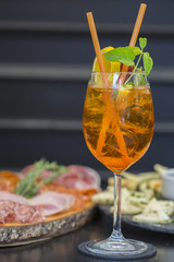 Traditional italian aperitif with proscioutto, mortadella sausage, cheese and aperol spritz drink