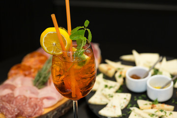 Traditional italian aperitif with proscioutto, mortadella sausage, cheese and aperol spritz drink