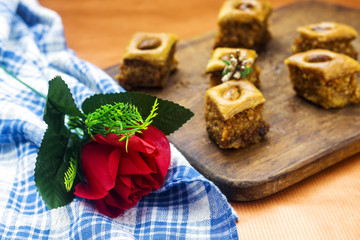 homemade traditional arabic dessert baklava with burned peanut decorated with red flowers for ramadan