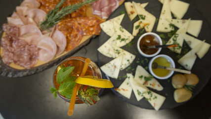 Traditional italian aperitif with proscioutto, mortadella sausage, cheese and aperol spritz drink