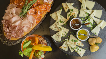 Traditional italian aperitif with proscioutto, mortadella sausage, cheese and aperol spritz drink