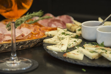 Traditional italian aperitif with proscioutto, mortadella sausage, cheese and aperol spritz drink