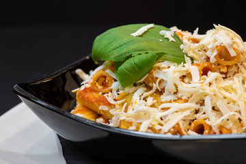 Pasta alla Norma - traditional Italian food with eggplant, tomato, cheese and basil