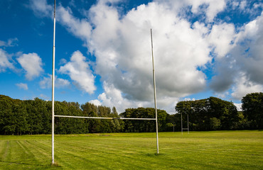 Goal post in a mowed grass playing field on a sunny summer day