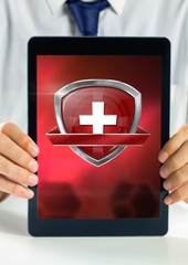 Health shield icon and hands holding tablet