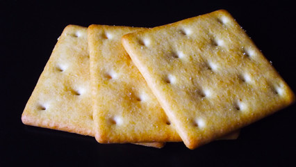 Delicious salty crackers on a black background.