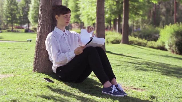 Business woman/student doing her tasks in the park.