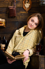 Relaxation concept. Girl student relaxing with book and glass of mulled wine. Lady on smiling face...