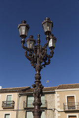 Fototapeta na wymiar Farola con esculturas y cuatro lámparas.