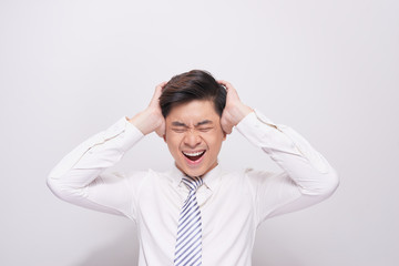 Shocked face of Asian man in white shirt on grey background.