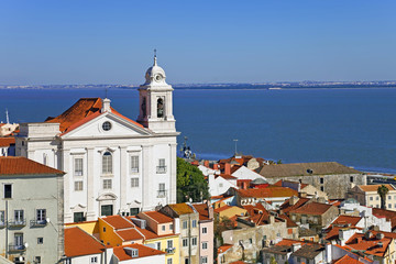 Alfama District with Santo Estevao Church and the Tagus River estuary seen from Miradouro de Santa Luzia viewpoint. Lisbon, Portugal.