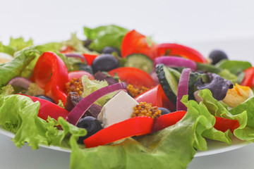 salad from fresh vegetables in a plate on a table, selective focus