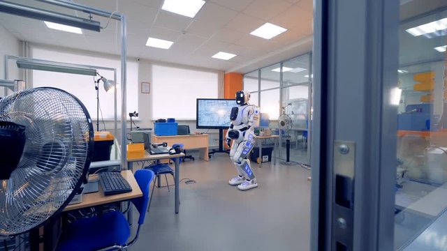 Engineering office room with a human-like robot in it