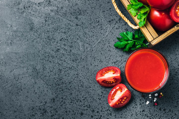 Salty tomato juice in glasses on dark concrete background. Top view, space for text.