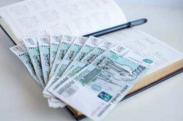 Opened diary and banknotes on white background