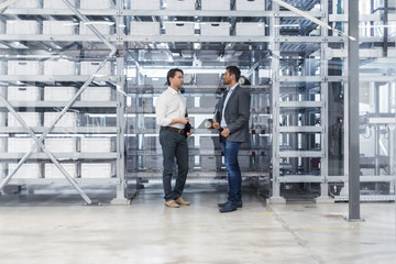 Two businessmen talking in modern factory