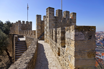 Lisbon, Portugal - February 1, 2013: Castelo de Sao Jorge aka Saint George Castle. Defensive walls with a view of the wallwalk, battlements, ramparts, merlons and crenels in the towers