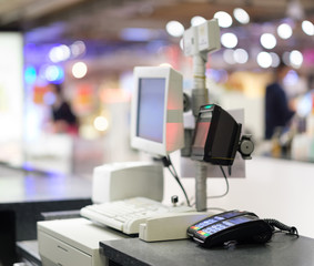 Rows of cash desks with cashiers and customers on blurry background