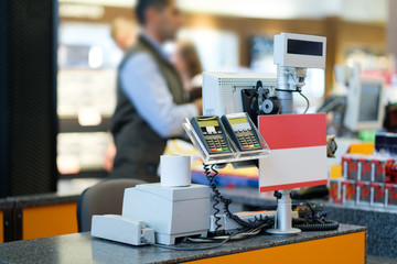 Rows of cash desks with cashiers and customers on blurry background