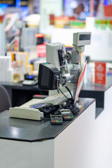 Rows of cash desks with cashiers and customers on blurry background