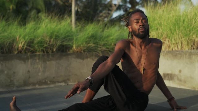 Man do yoga spine twisting pose at rooftop with solar battery rapid slow motion