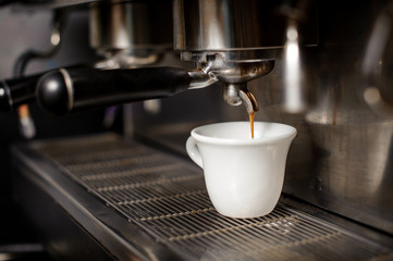 White ceramic cup of coffee in the coffee mahine