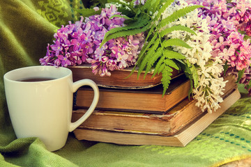 lilac, books and a Cup of tea on a bench