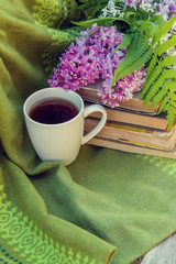 lilac, books and a Cup of tea on a bench