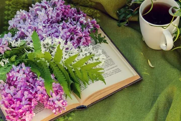 Photo sur Aluminium Lilas lilas, livres et une tasse de thé sur un banc