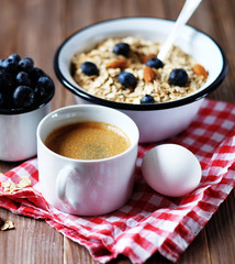 A healthy breakfast - Oatmeal porridge, boiled egg, milk, fresh berries and coffee. A great start to a new day.