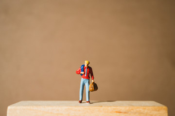 Miniature people, businessman standing on wooden block using as business concept