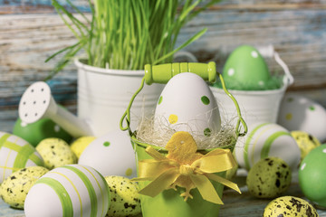 Easter still life, postcard - Rustic still life with Easter eggs in buckets, watering can and wooden background