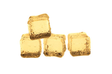 Golden ice cubes on white background.